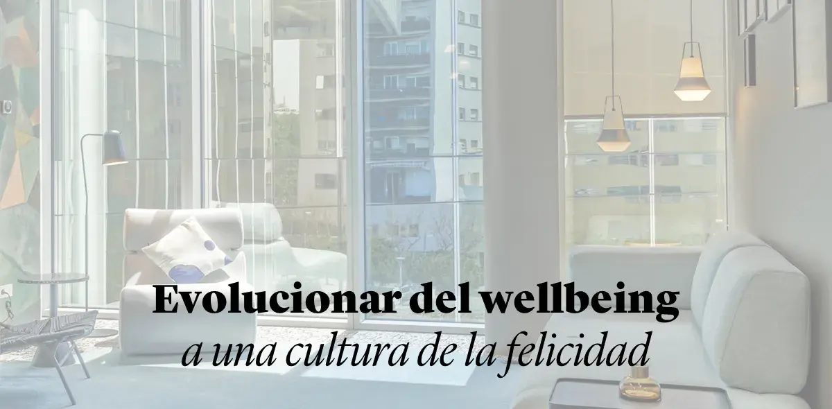Un moderno salón con sofás blancos y ventanales amplios deja entrar luz natural.