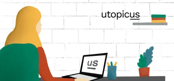 Una persona usa una laptop en un escritorio con lápices y una planta, frente a una pared de ladrillos blancos.