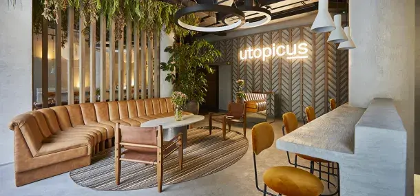 Un sofá curvo color marrón en una sala moderna con plantas colgantes.
