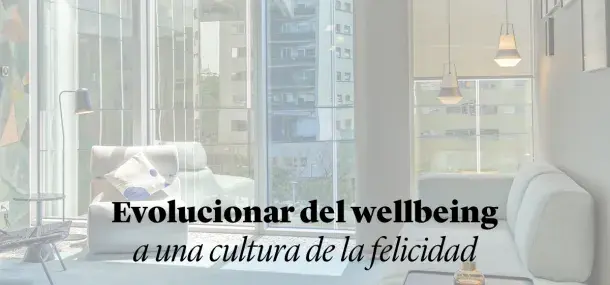 Un moderno salón con sofás blancos y ventanales amplios deja entrar luz natural.
